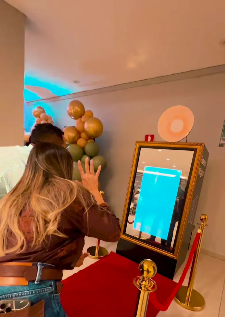 Convidada tocando a tela do Espelho Mágico